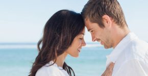 Romantic couple relaxing and embracing on the beach during the s