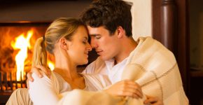 affectionate young couple in love cuddling near fireplace