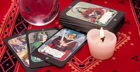 Tarot cards in pouch  and crystal ball on red cloth