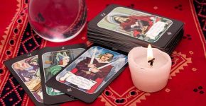 Tarot cards in pouch  and crystal ball on red cloth