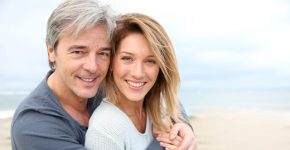 Cheerful mature couple embracing by the beach