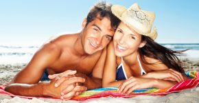 Attractive couple lying on a towel on the beach