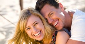 Happy couple embracing and laughing on the beach