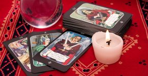 Tarot cards in pouch  and crystal ball on red cloth